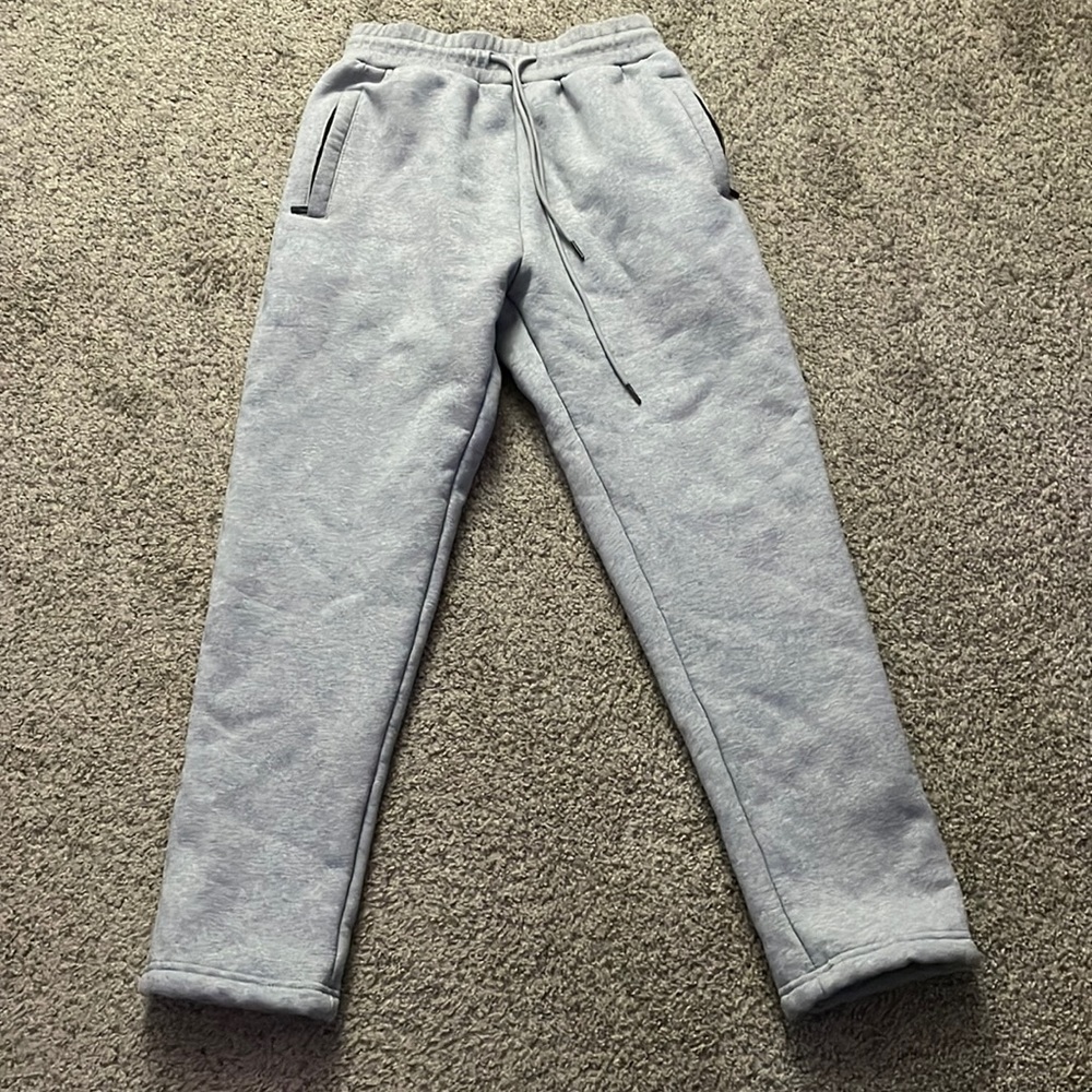 Fleece Lined sweat pants with a drawstring waistband and zip up pockets.
